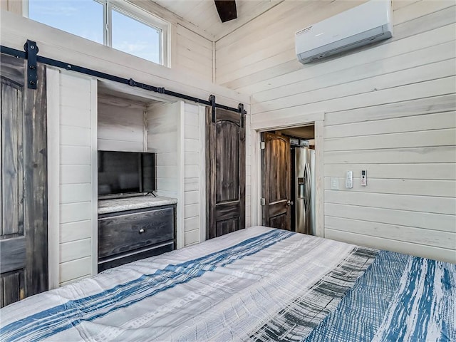 unfurnished bedroom featuring a barn door, a wall mounted AC, stainless steel fridge, and wooden walls