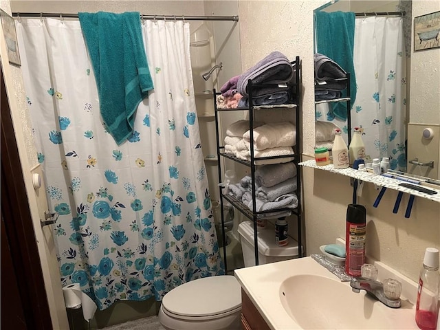 bathroom featuring curtained shower, vanity, and toilet