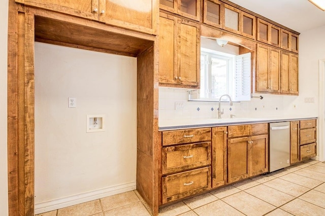 kitchen with brown cabinetry, tasteful backsplash, dishwasher, and a sink