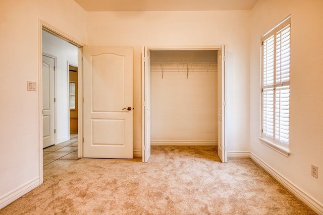 unfurnished bedroom featuring a closet, baseboards, and carpet floors