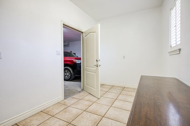 unfurnished room with light tile patterned floors and baseboards
