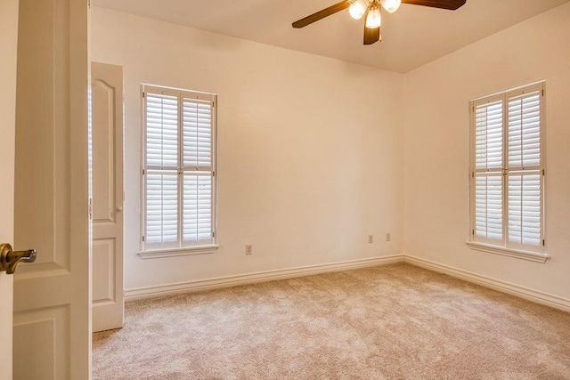 carpeted spare room with ceiling fan, baseboards, and a wealth of natural light