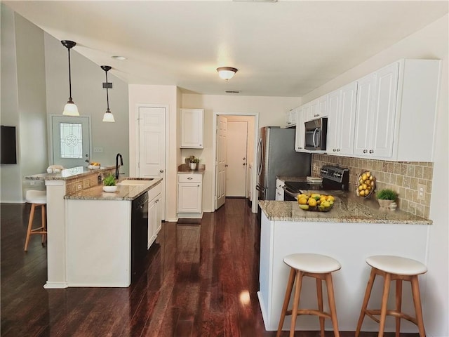 kitchen with white cabinetry, appliances with stainless steel finishes, decorative light fixtures, and sink