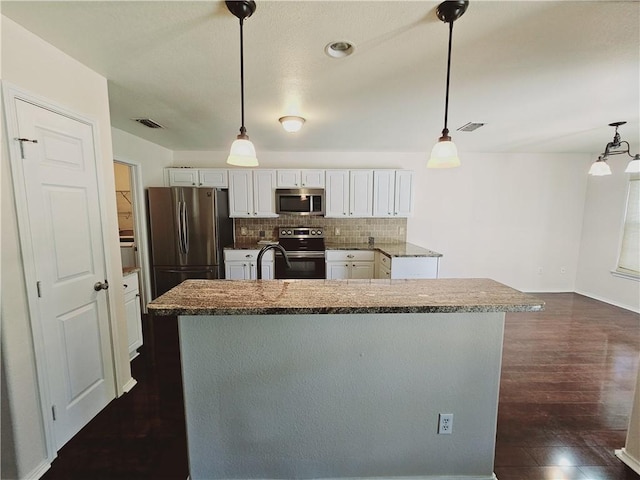 kitchen with white cabinetry, appliances with stainless steel finishes, decorative light fixtures, and tasteful backsplash