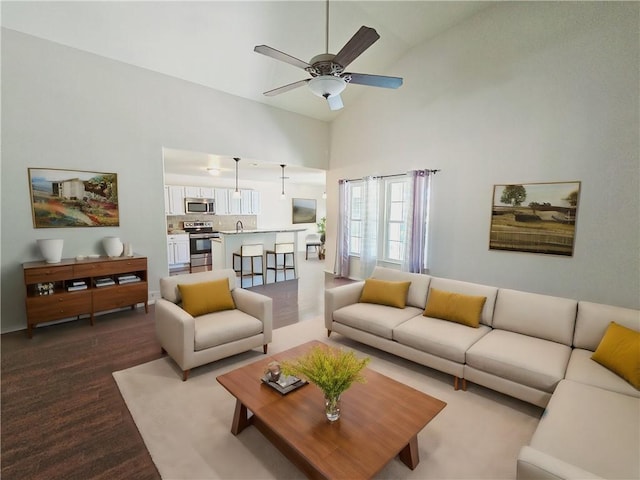 living room with ceiling fan, high vaulted ceiling, and light wood-type flooring