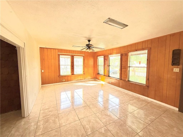 1609 15th St, Corpus Christi, TX 78404 - spare room with plenty of natural light, a ceiling fan, wooden walls, and a textured ceiling