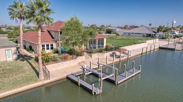 411 Porpoise Dr, Aransas Pass, TX 78336 - view of dock featuring boat lift, a residential view, a water view, and a lawn