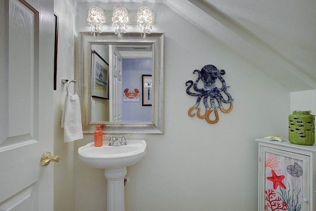 bathroom with sink and lofted ceiling