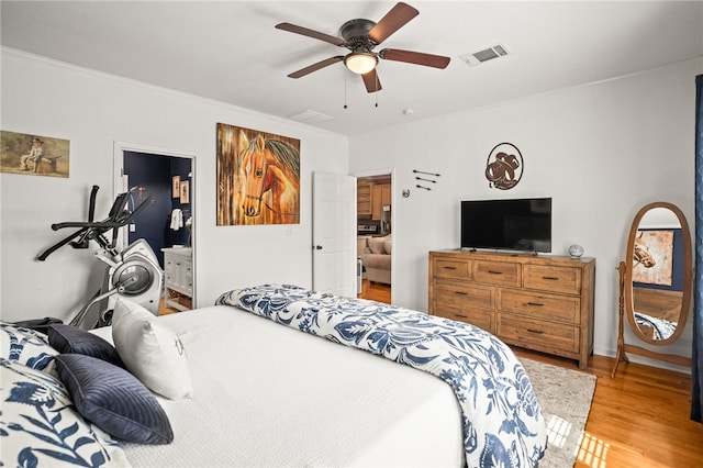 bedroom featuring crown molding, a ceiling fan, light wood finished floors, and visible vents