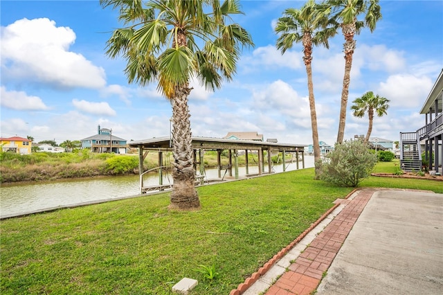 view of yard featuring a water view, a dock, stairs, and boat lift