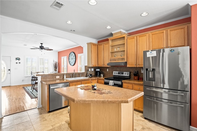 kitchen featuring visible vents, arched walkways, a sink, under cabinet range hood, and stainless steel appliances