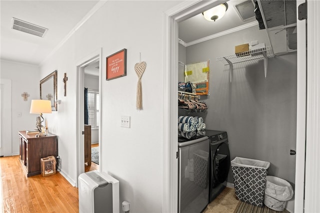spacious closet with visible vents, washer and clothes dryer, and light wood-style floors