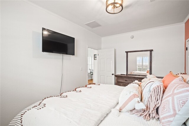 bedroom with crown molding and visible vents