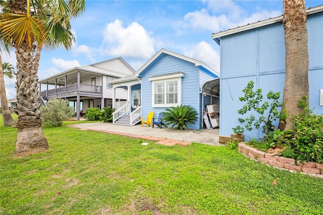 back of property featuring a detached carport and a yard