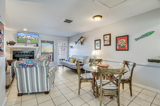 tiled dining room with a tiled fireplace