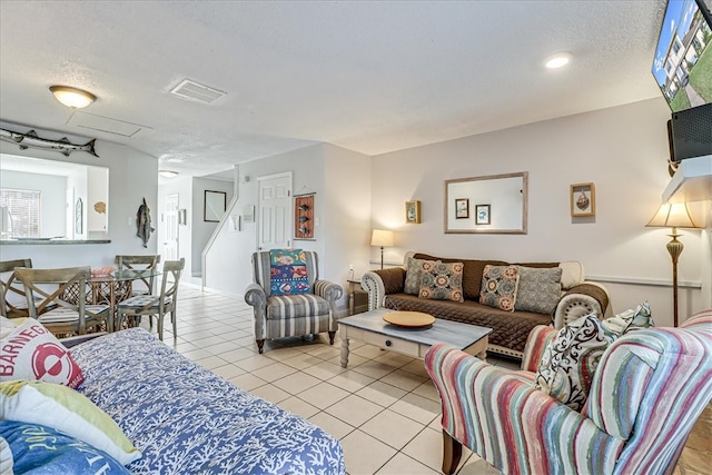 living room with a textured ceiling and light tile patterned floors