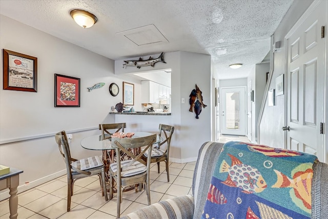 tiled dining space featuring a textured ceiling