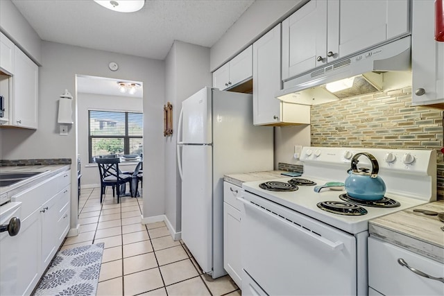 kitchen with white cabinets, decorative backsplash, light tile patterned floors, and white appliances