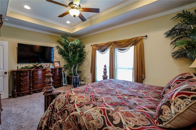 bedroom featuring ceiling fan, carpet floors, a raised ceiling, and ornamental molding