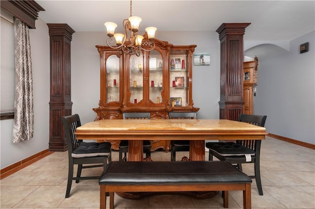 dining space featuring a chandelier, light tile patterned floors, and ornate columns