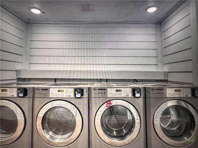 washroom with independent washer and dryer and wooden walls