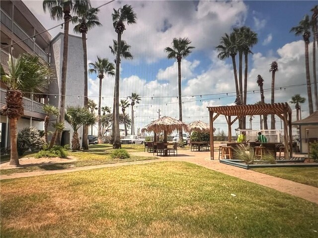 view of community with a yard and a pergola