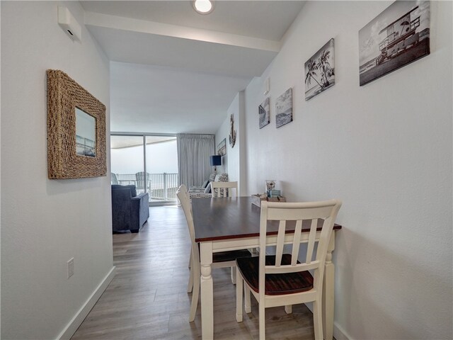 dining area with floor to ceiling windows and hardwood / wood-style floors