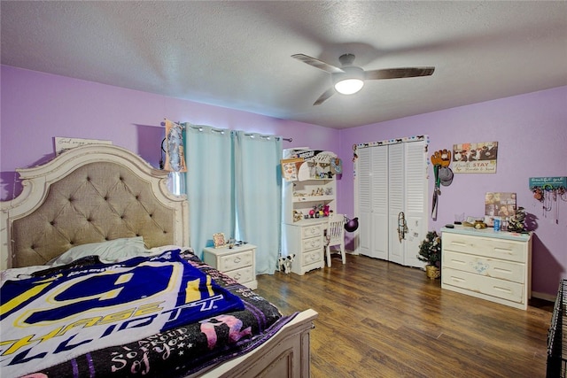 bedroom featuring a textured ceiling, ceiling fan, dark wood-type flooring, and a closet