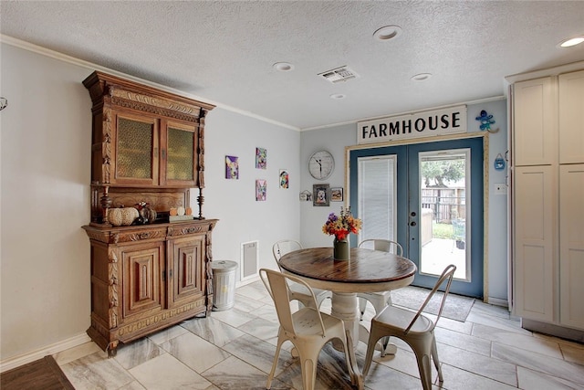 dining area with french doors, a textured ceiling, and ornamental molding