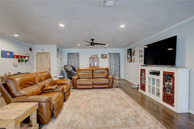 living room featuring hardwood / wood-style floors, a textured ceiling, ceiling fan, and ornamental molding