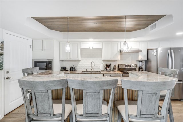 1000 Lantana Dr Unit 903, Port Aransas, TX 78373 - kitchen with a sink, a tray ceiling, appliances with stainless steel finishes, under cabinet range hood, and wood ceiling