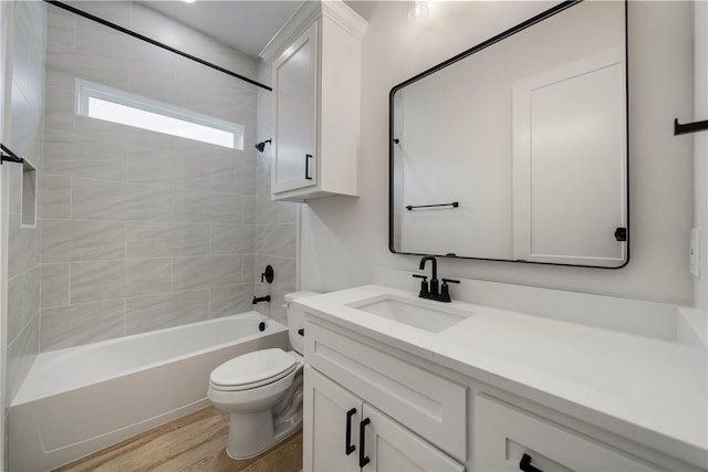 full bathroom with toilet, vanity, hardwood / wood-style flooring, and tiled shower / bath