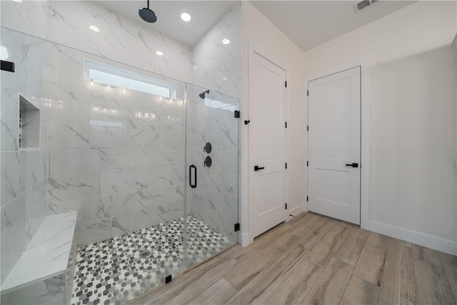 bathroom featuring hardwood / wood-style floors and a shower with shower door