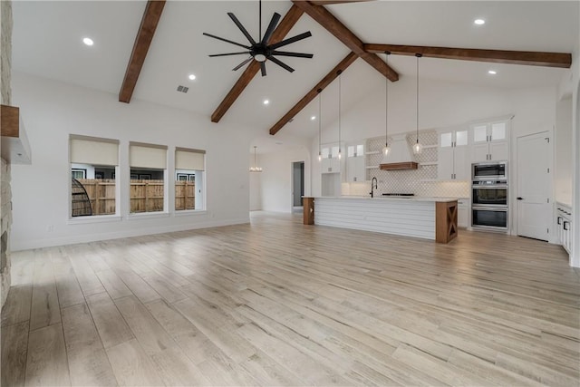 unfurnished living room featuring sink, high vaulted ceiling, ceiling fan, and light hardwood / wood-style flooring