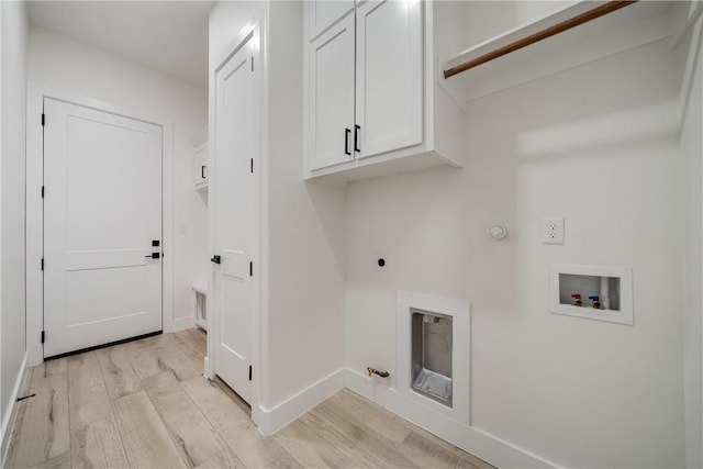 laundry area with washer hookup, gas dryer hookup, light hardwood / wood-style flooring, and cabinets