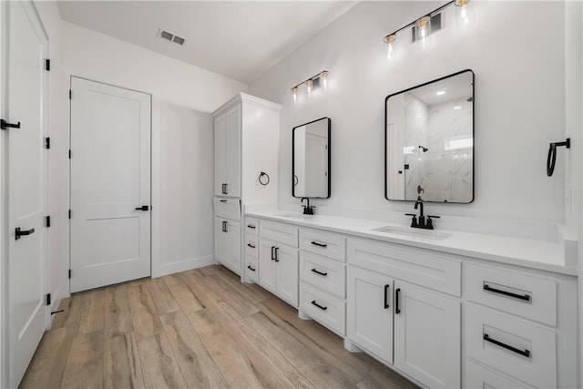 bathroom featuring a shower, wood-type flooring, and vanity