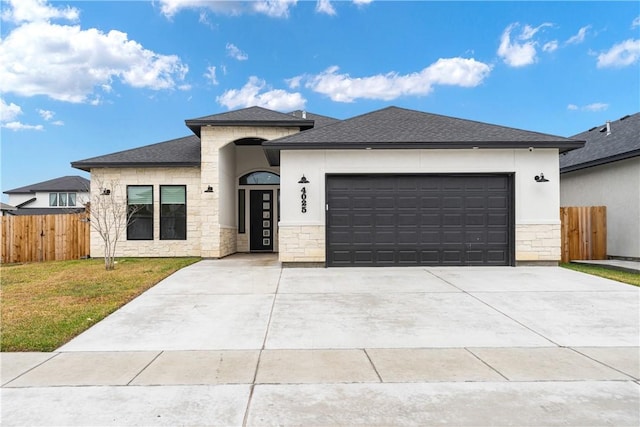 prairie-style home featuring a front yard and a garage