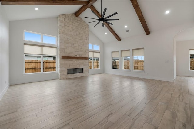 unfurnished living room featuring a fireplace, high vaulted ceiling, ceiling fan, and light hardwood / wood-style floors