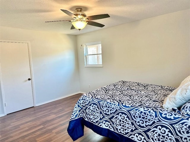 bedroom featuring hardwood / wood-style floors, a textured ceiling, and ceiling fan