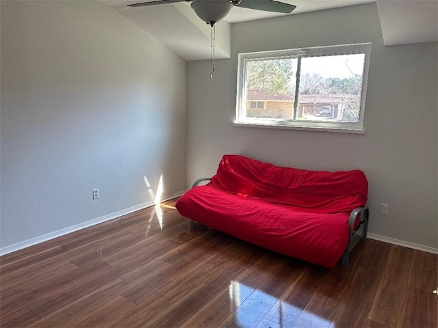 living area featuring ceiling fan and dark hardwood / wood-style flooring