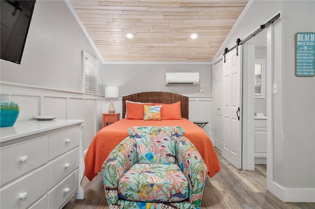 bedroom featuring ornamental molding, an AC wall unit, a barn door, and wooden ceiling