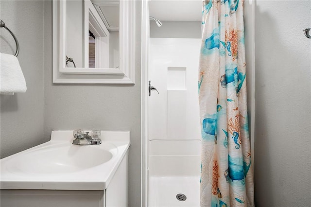 full bathroom with a shower stall and vanity