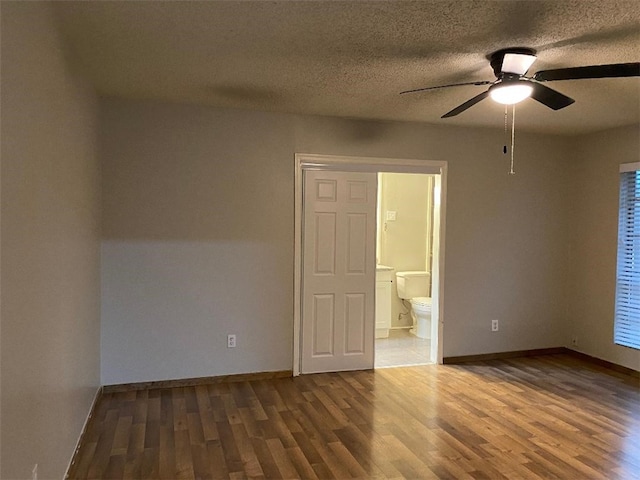 spare room with ceiling fan, wood-type flooring, and a textured ceiling