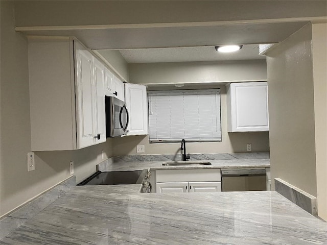 kitchen with white cabinets, light stone countertops, sink, and appliances with stainless steel finishes