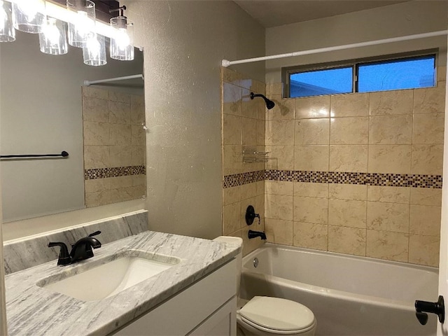 full bathroom featuring tiled shower / bath combo, toilet, and vanity