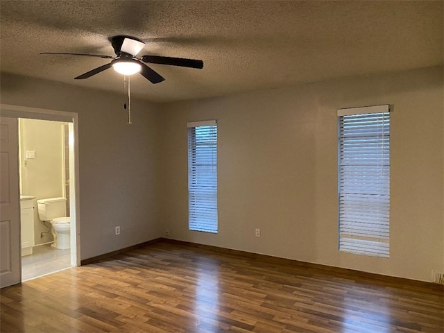 interior space featuring ceiling fan, wood-type flooring, and a textured ceiling