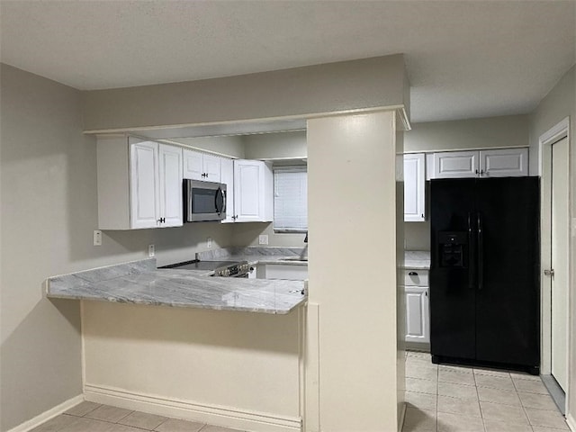 kitchen featuring light stone countertops, kitchen peninsula, stainless steel appliances, light tile patterned floors, and white cabinetry