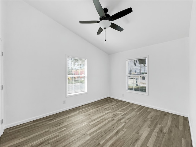 spare room with hardwood / wood-style floors, vaulted ceiling, and ceiling fan