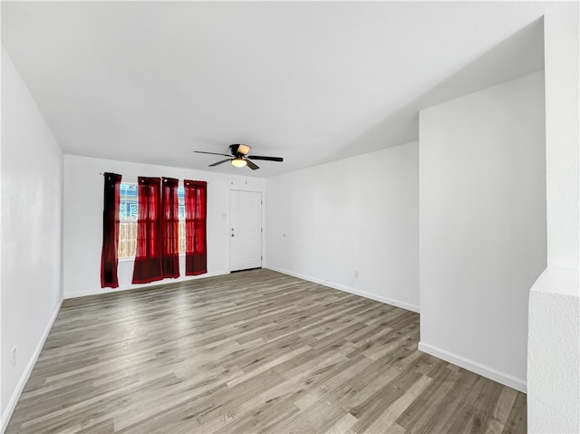 spare room with ceiling fan and light wood-type flooring