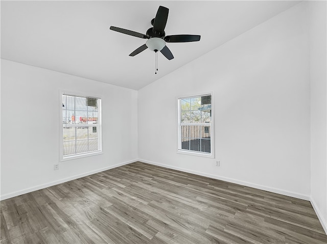 empty room with ceiling fan, vaulted ceiling, and hardwood / wood-style flooring